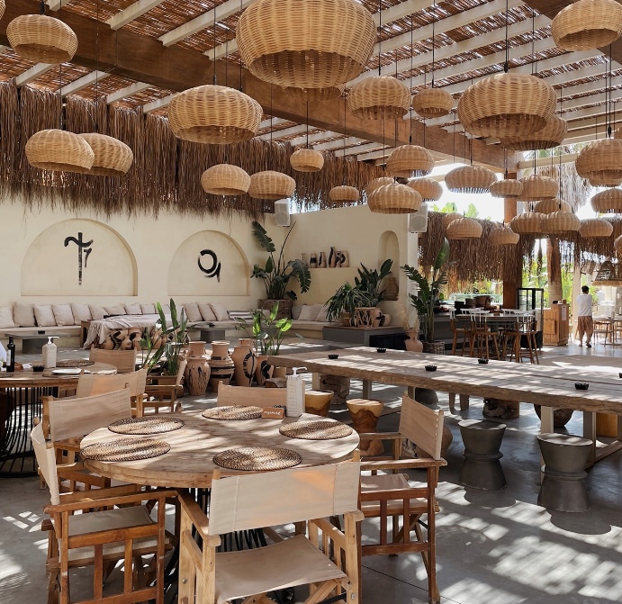 3 Cách Chọn Nội Thất Quán Cà Phê – Giải Pháp Tối Ưu Không Gian 6 Nội thất quán cà phê phong cách Bohemian với trần mây tre, bàn ghế gỗ mộc và không gian mở hòa mình với thiên nhiên.